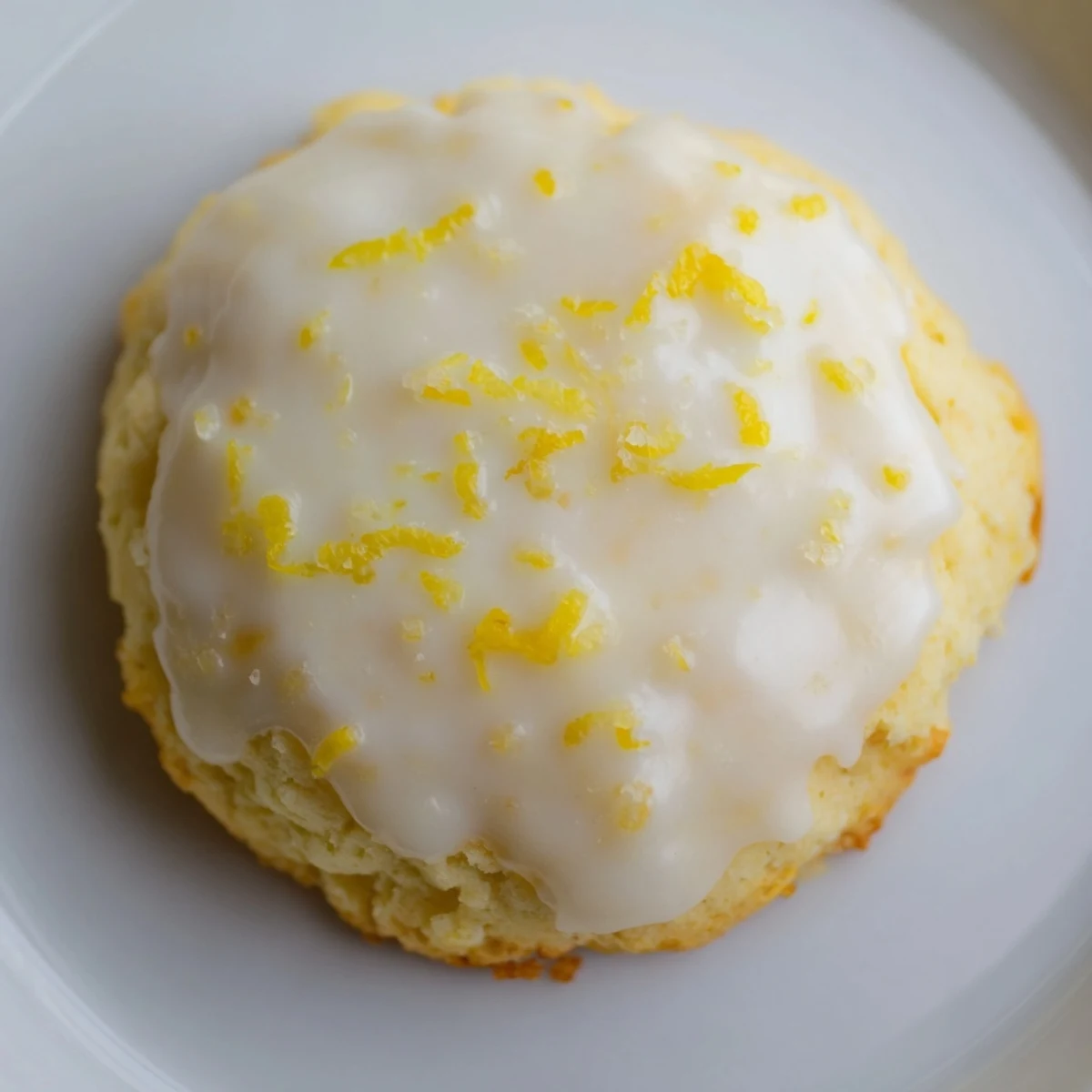 Lemon Ricotta Cookies with Glaze stacked on a white plate, with a cup of tea nearby for a cozy dessert suggestion.
