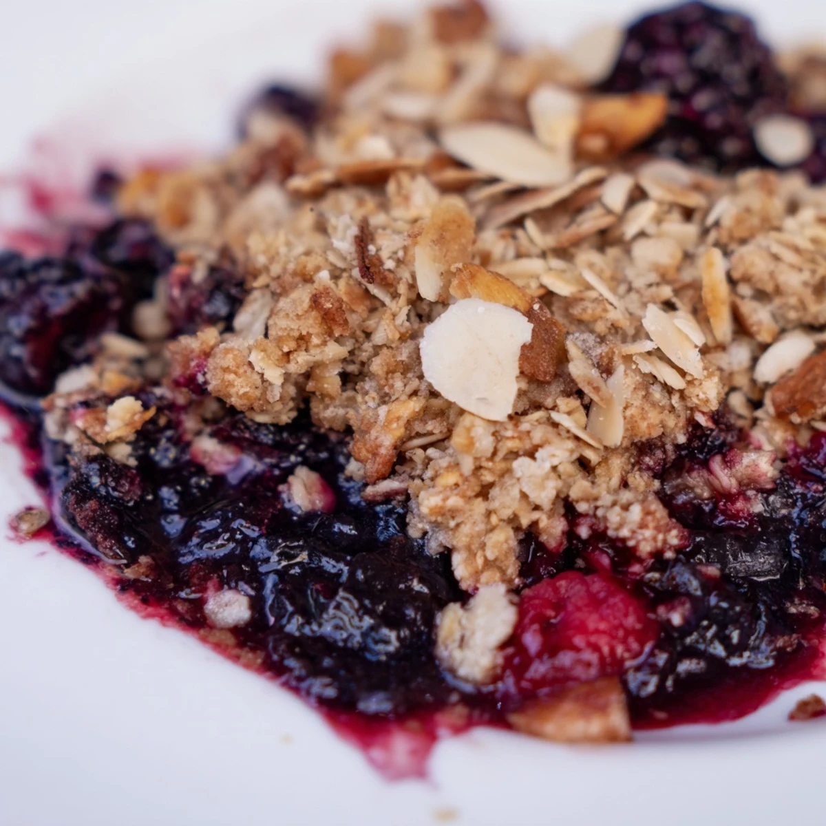 Rustic ceramic dish holds homemade Winter Berry Crumble with Oats, featuring a hearty texture of oats, almonds, and mixed winter berries.