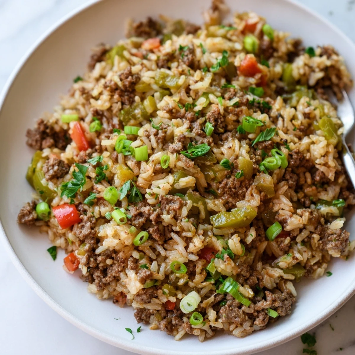 Hearty Cajun Dirty Rice with Ground Beef and Peppers, featuring spiced beef and vibrant bell peppers on a plate, ready for dinner.