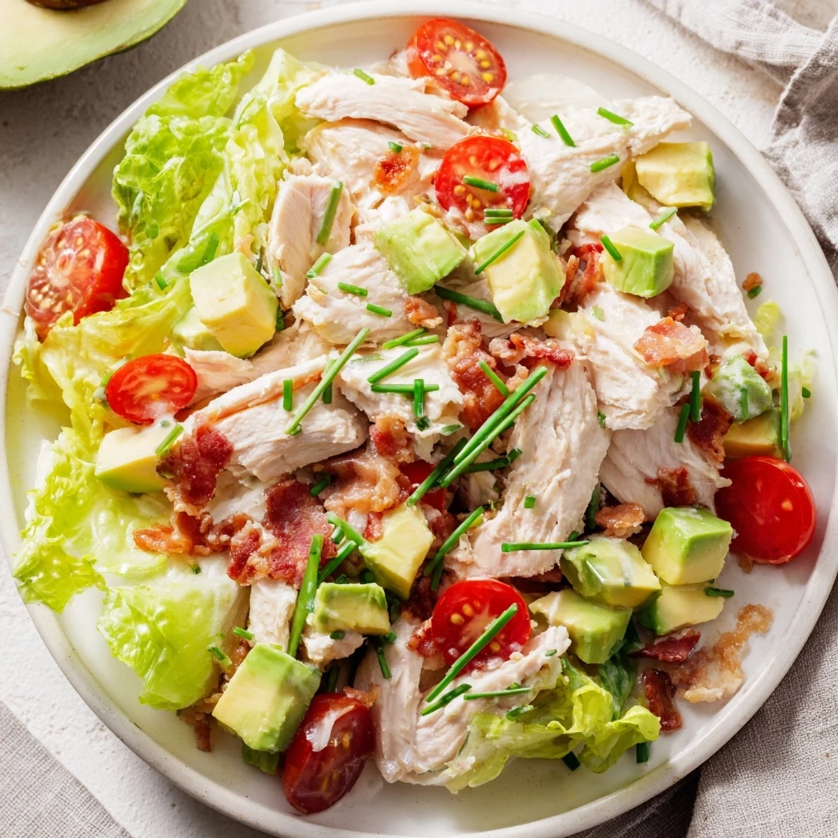 Colorful BLT Chicken Salad for a healthy American main dish, mixing tender chicken, fresh lettuce, bright tomatoes, and onion slices ready for dinner.