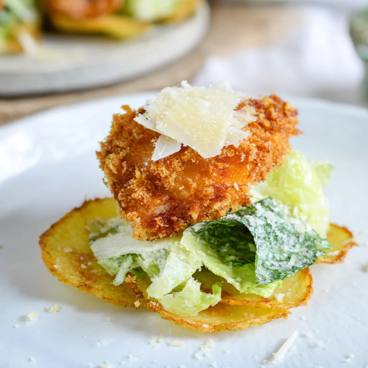 A close view shows Crispy Chicken Caesar Salad Chips plated with lemon wedges and shaved parmesan for dipping.