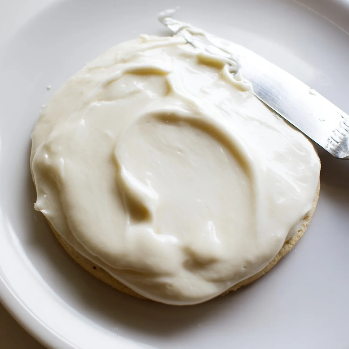 Brightly colored Easy Sugar Cookie Frosting dries to a glossy finish on a platter of freshly frosted American desserts.