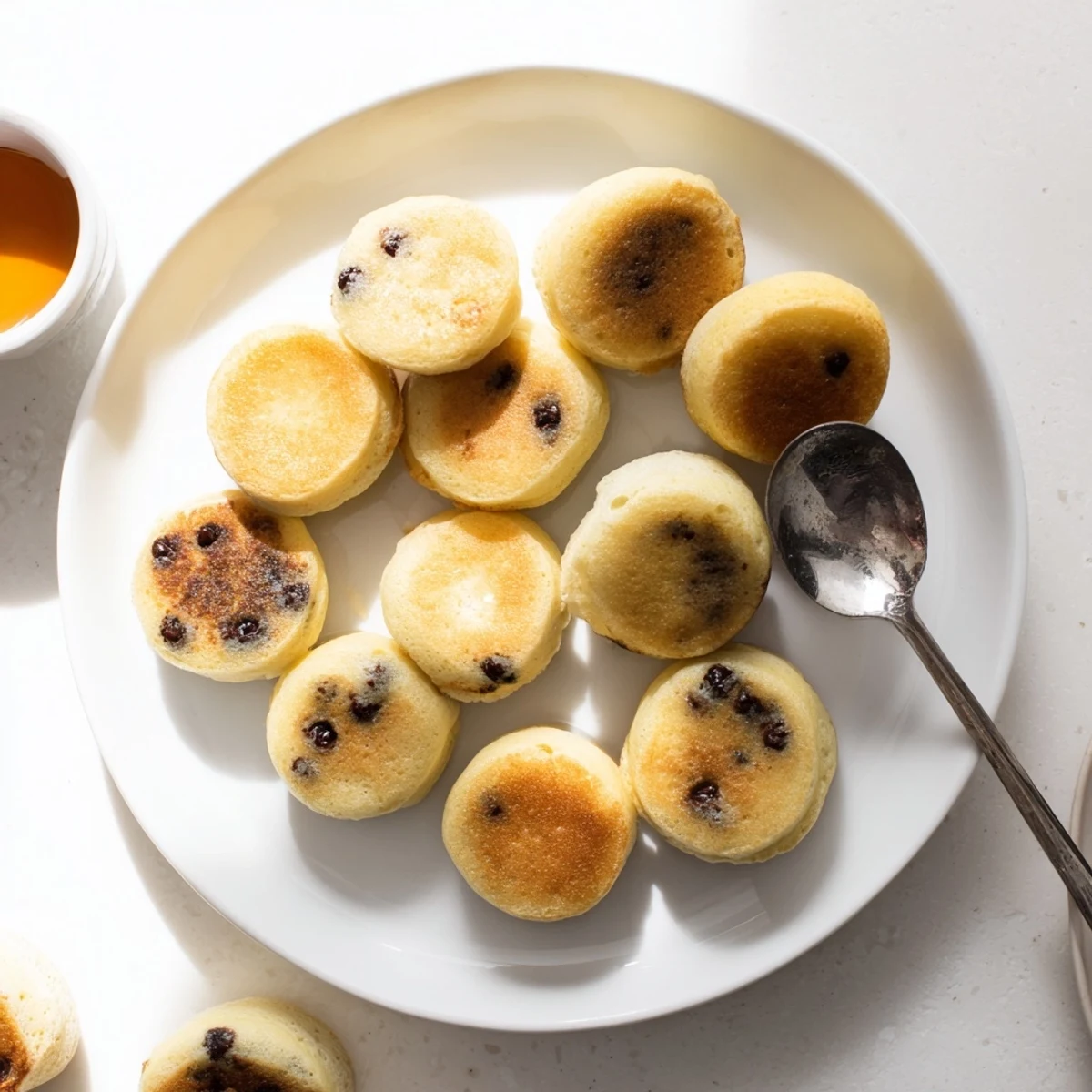 A close-up of freshly baked Pancake Poppers topped with a pat of melting butter and syrup.