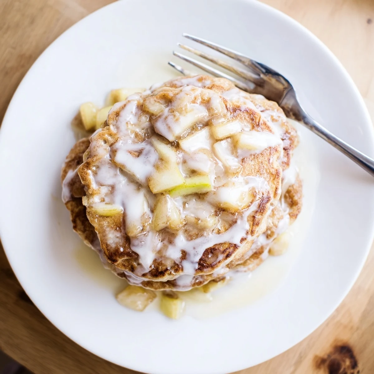 Freshly cooked Apple Fritter Pancakes with tender apple chunks and cinnamon, stacked high and ready for a cozy breakfast.  