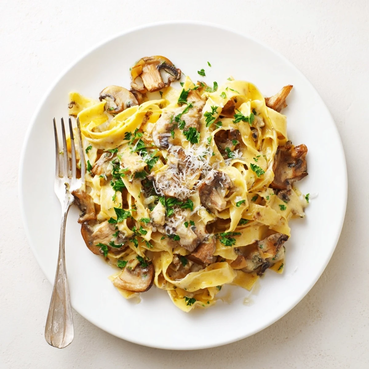 Savory truffle mushroom pasta served with fresh parsley and Parmesan cheese.