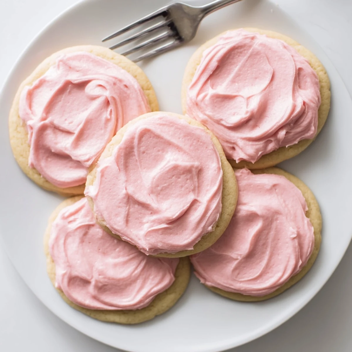A close-up shows Crumbl Sugar Cookies with bakery-style texture, finished with vibrant pink frosting and ready for an afternoon dessert.