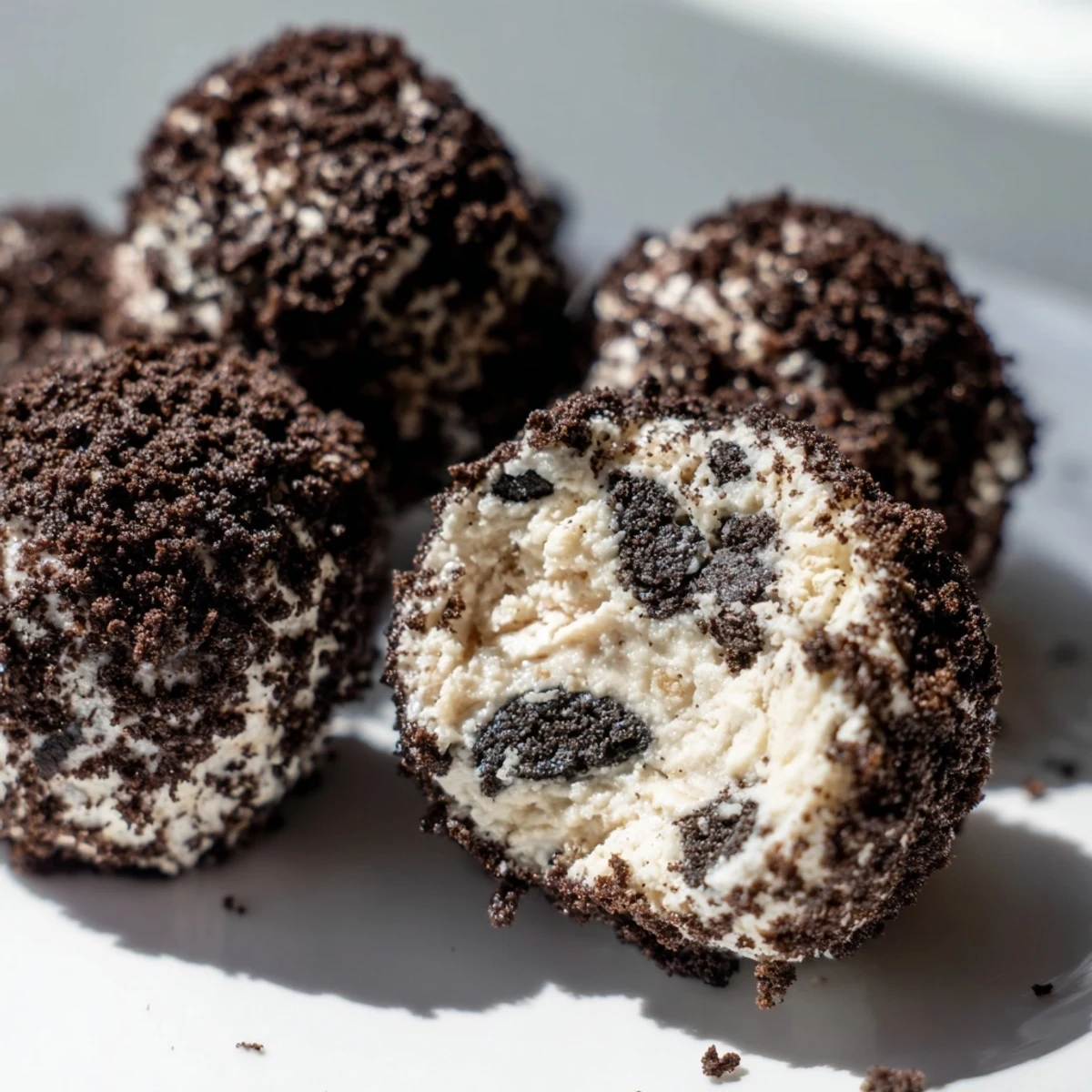 Cream cheese Oreo protein balls rolled in cookie crumbs, with a soft, sweet center ready to enjoy.