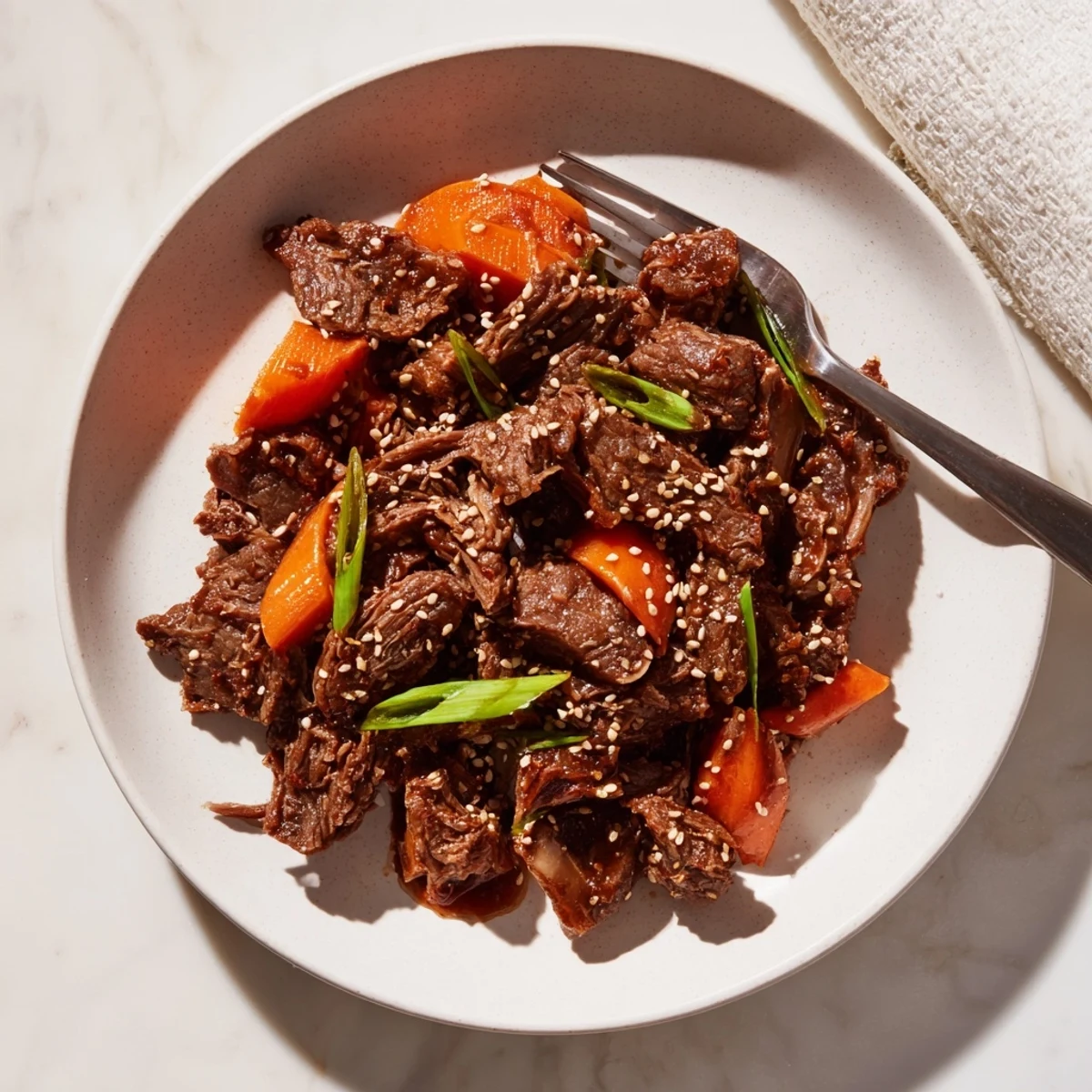 Tender Korean Style Pot Roast served over fluffy white rice, garnished with scallions and sesame seeds for a family dinner.