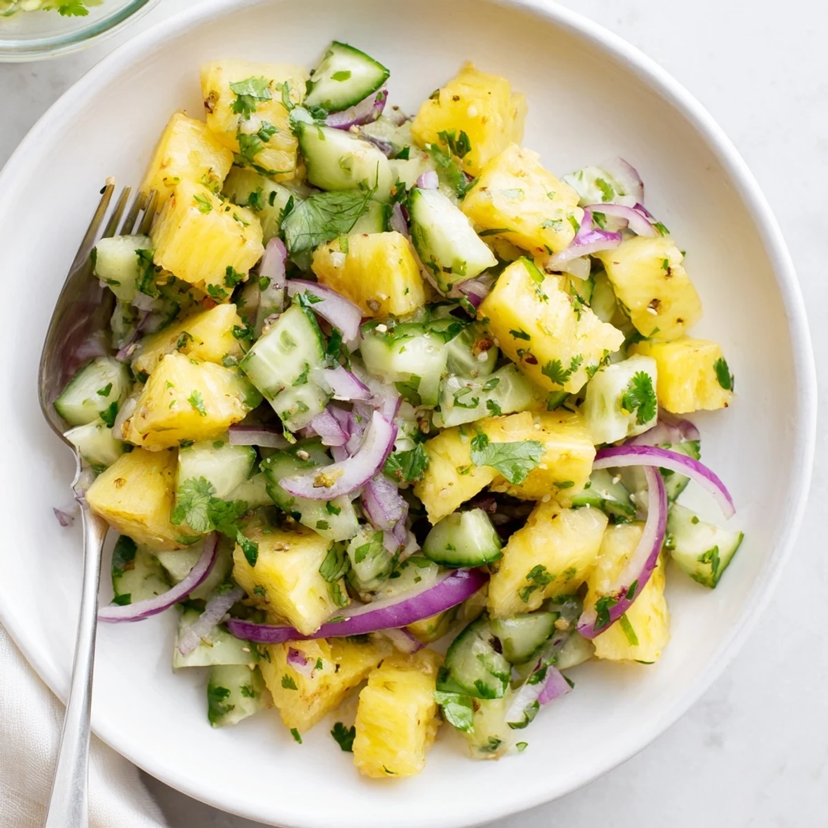 Vibrant tropical pineapple cucumber salad with colorful diced vegetables and fresh cilantro garnish