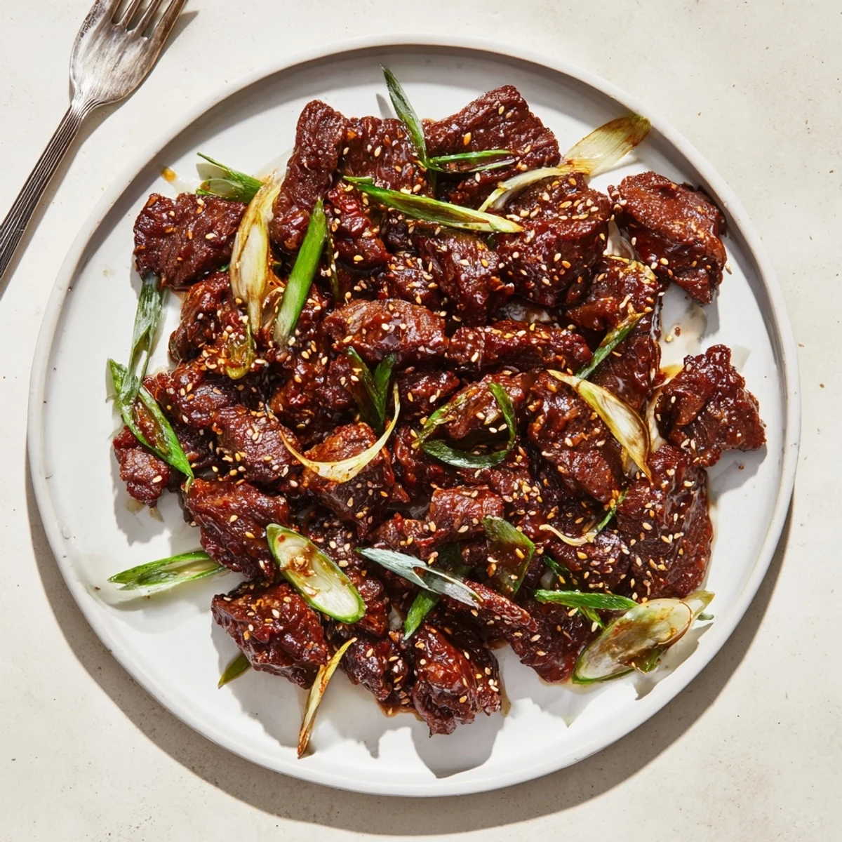 Tender shredded slow cooker Korean beef in rich glossy sauce with green onions