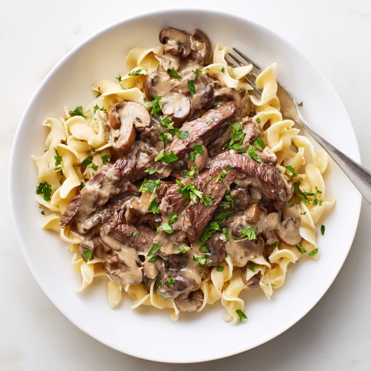 Tender beef strips in rich mushroom sauce over a bed of noodles