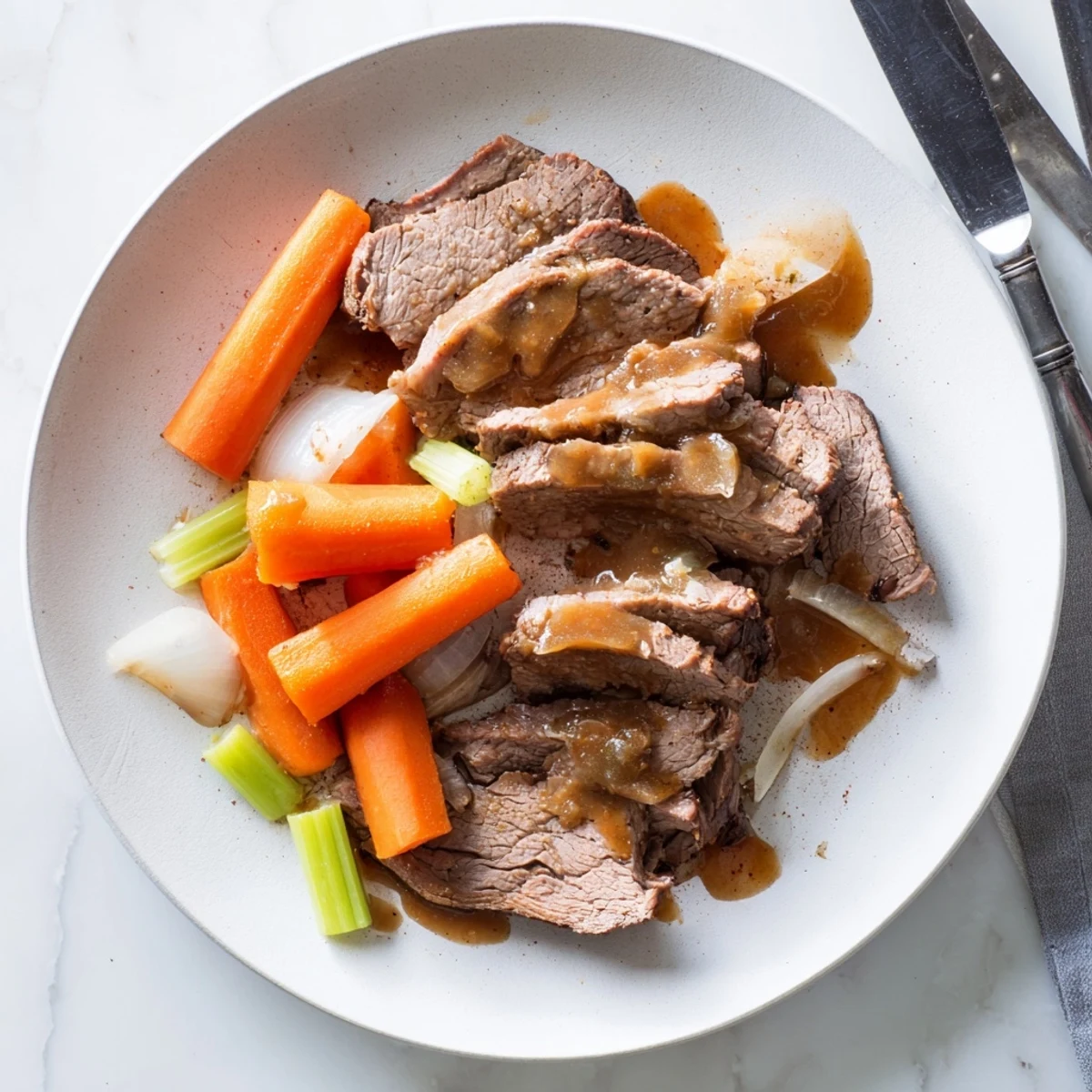 Fork-tender slow cooker beef brisket plated with vegetables and drizzled with rich savory sauce
