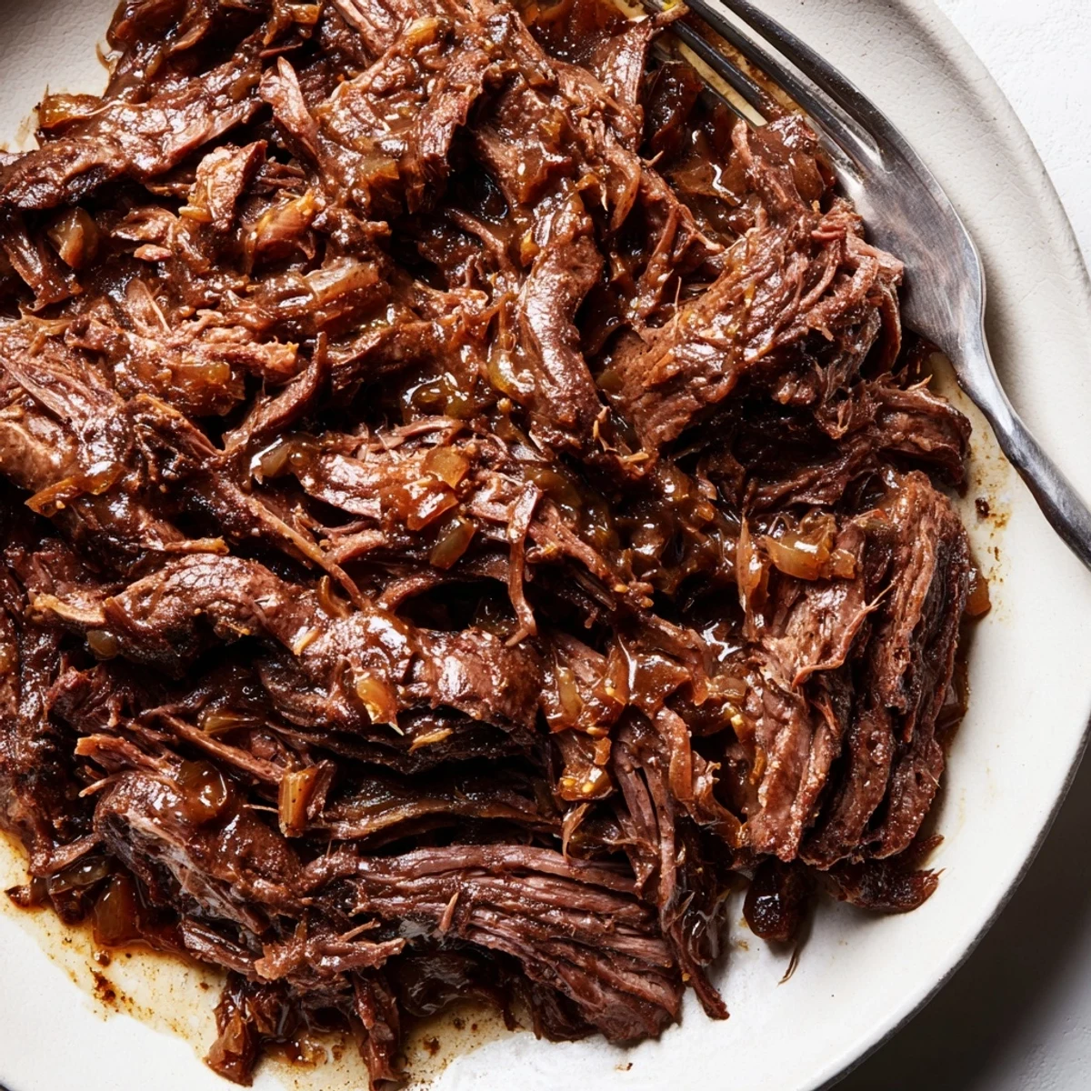 Slow cooker Crock Pot shredded beef with tender meat falling apart in rich dark juices