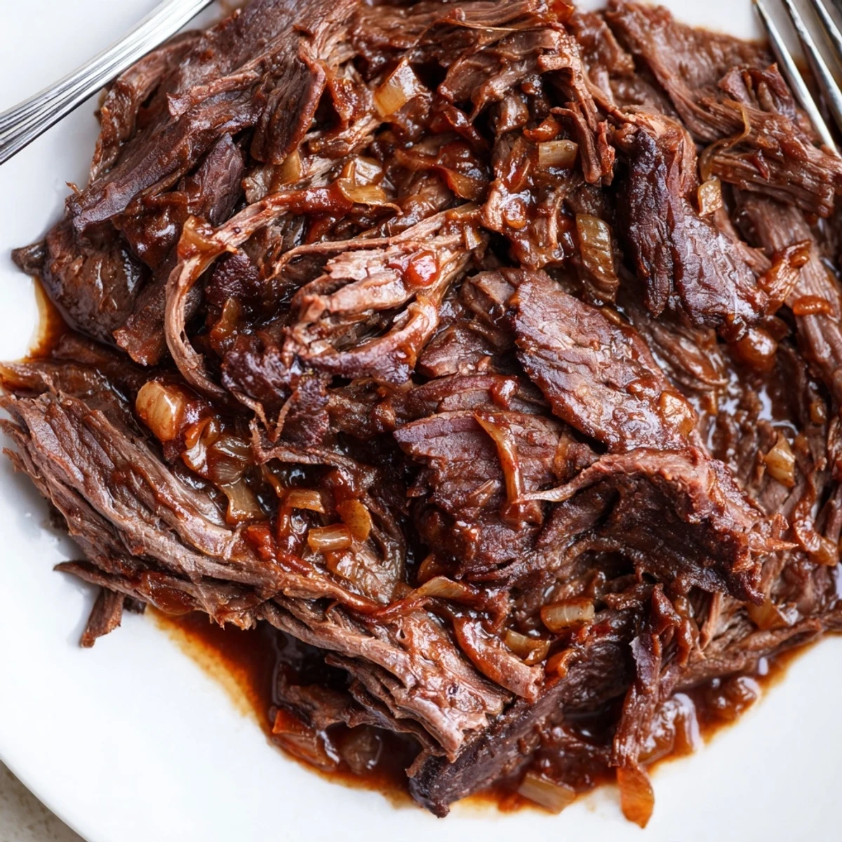 Golden brown Crock Pot shredded beef glistening with savory cooking juices and aromatic spices