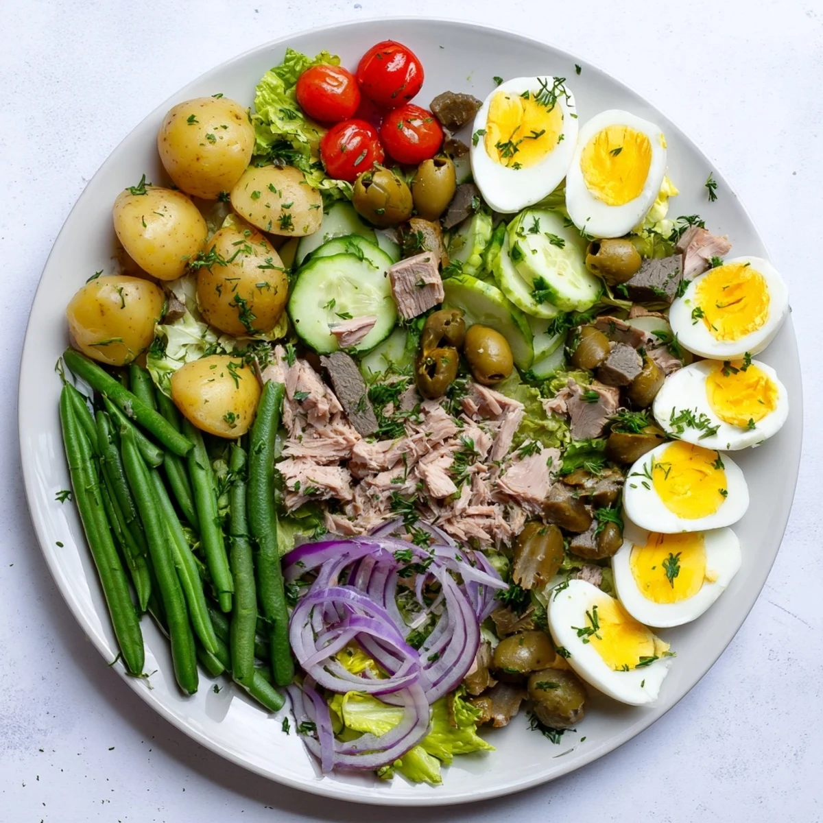 Vibrant Classic Niçoise Salad plated with tuna, boiled eggs, olives, and fresh crisp vegetables