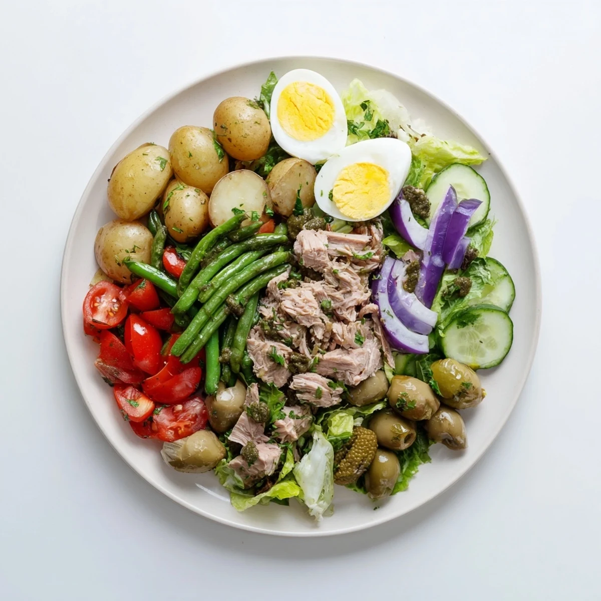 Colorful Classic Niçoise Salad topped with flaked tuna, cherry tomatoes, and tangy vinaigrette dressing
