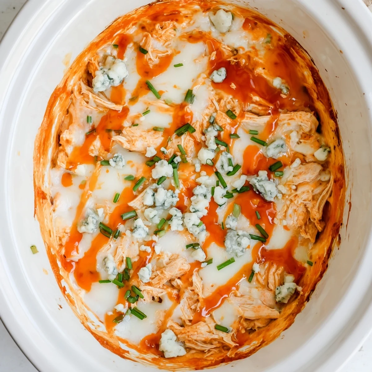 Creamy Crockpot Buffalo Chicken Dip bubbling with melted cheddar and mozzarella cheeses in a slow cooker