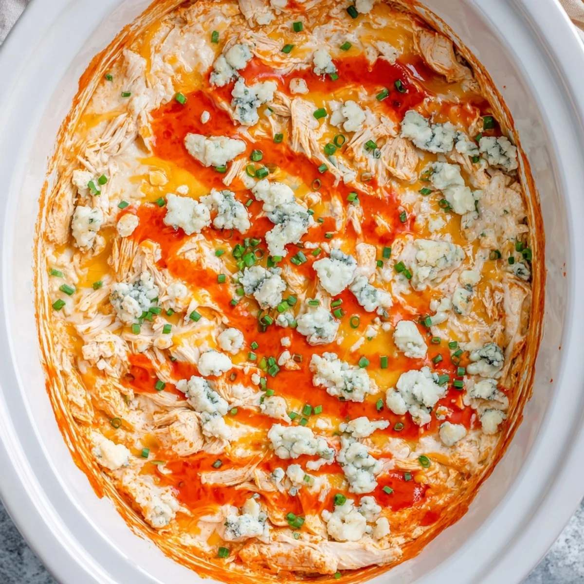 Golden shredded chicken mixed with spicy buffalo sauce and ranch in a rich, cheesy dip
