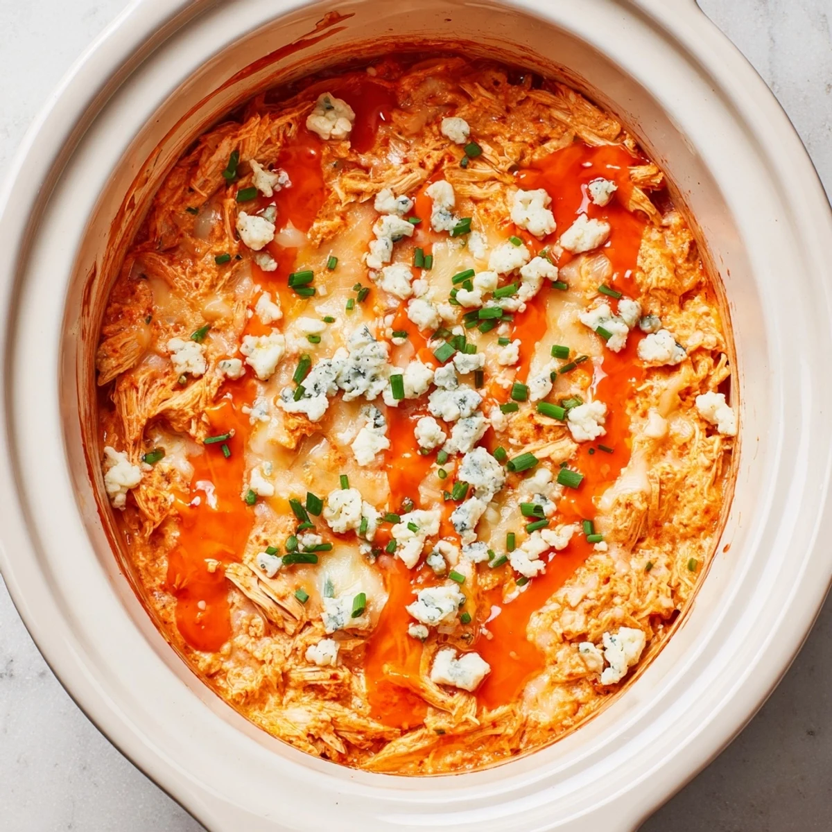 Warm buffalo chicken dip topped with fresh chives and served with crispy tortilla chips for dipping