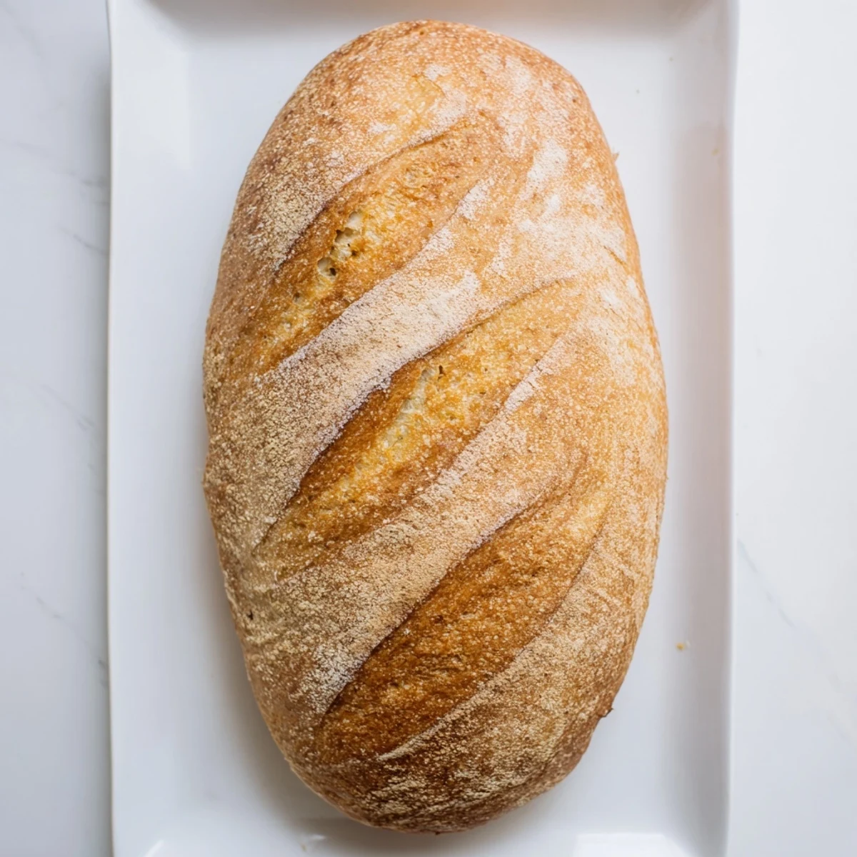 Freshly baked crusty Italian bread cooling on wire rack with golden crackly exterior and soft interior