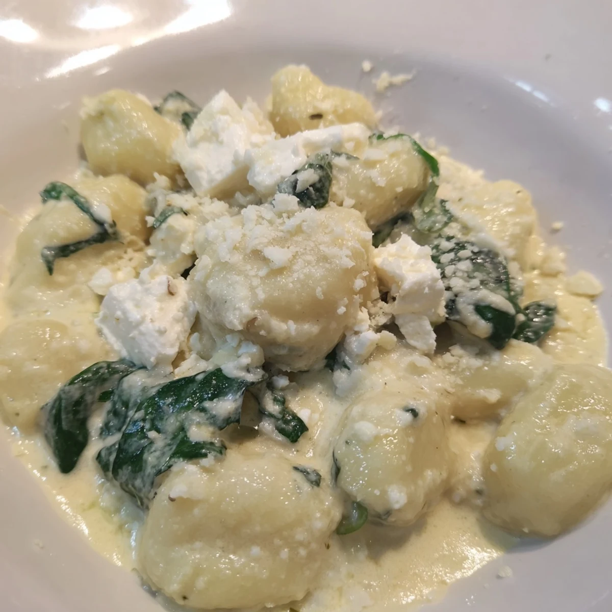 Soft pillowy gnocchi with spinach and feta swimming in rich white sauce
