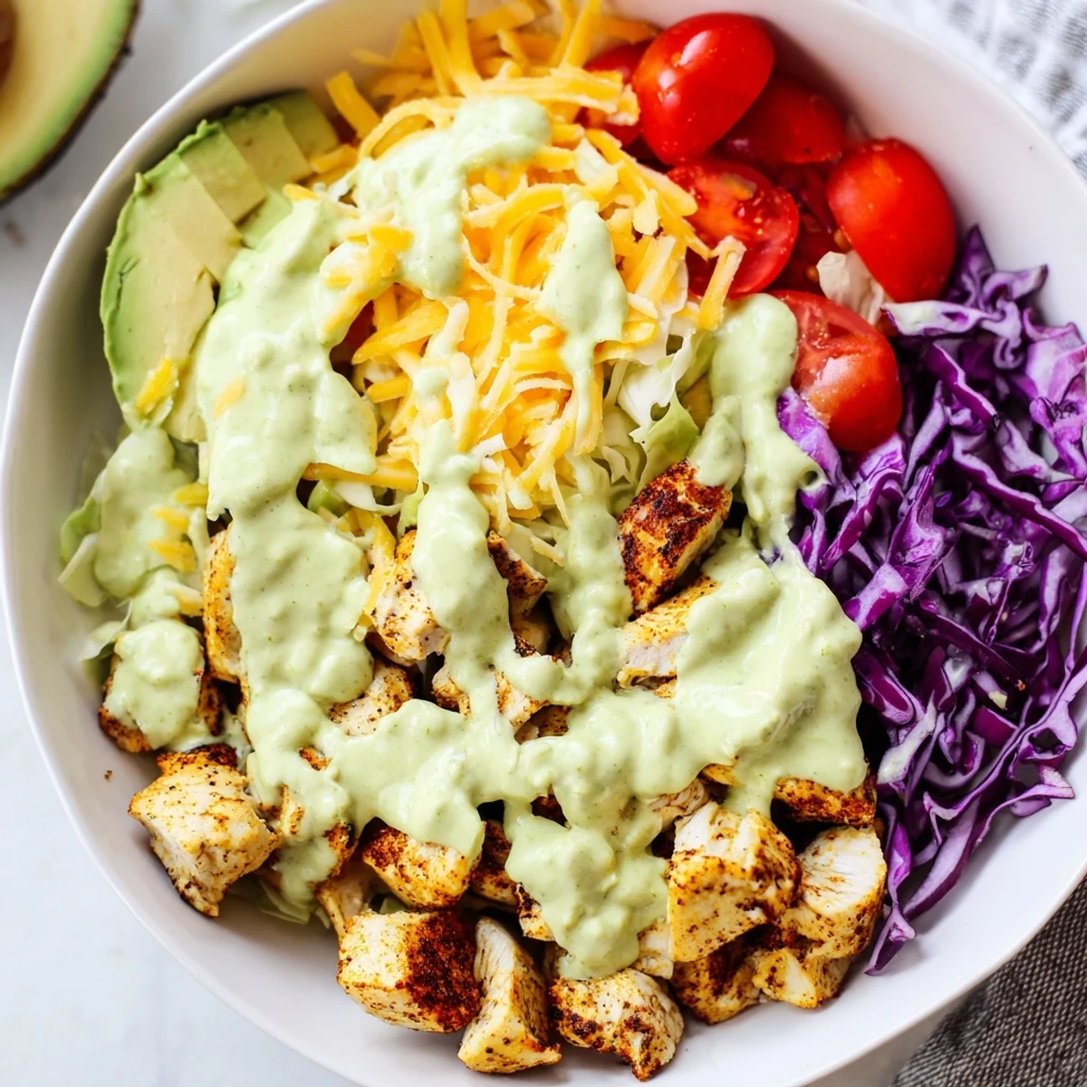 Keto bowls featuring crisp romaine, vibrant vegetables, and golden seasoned chicken topped with cheese