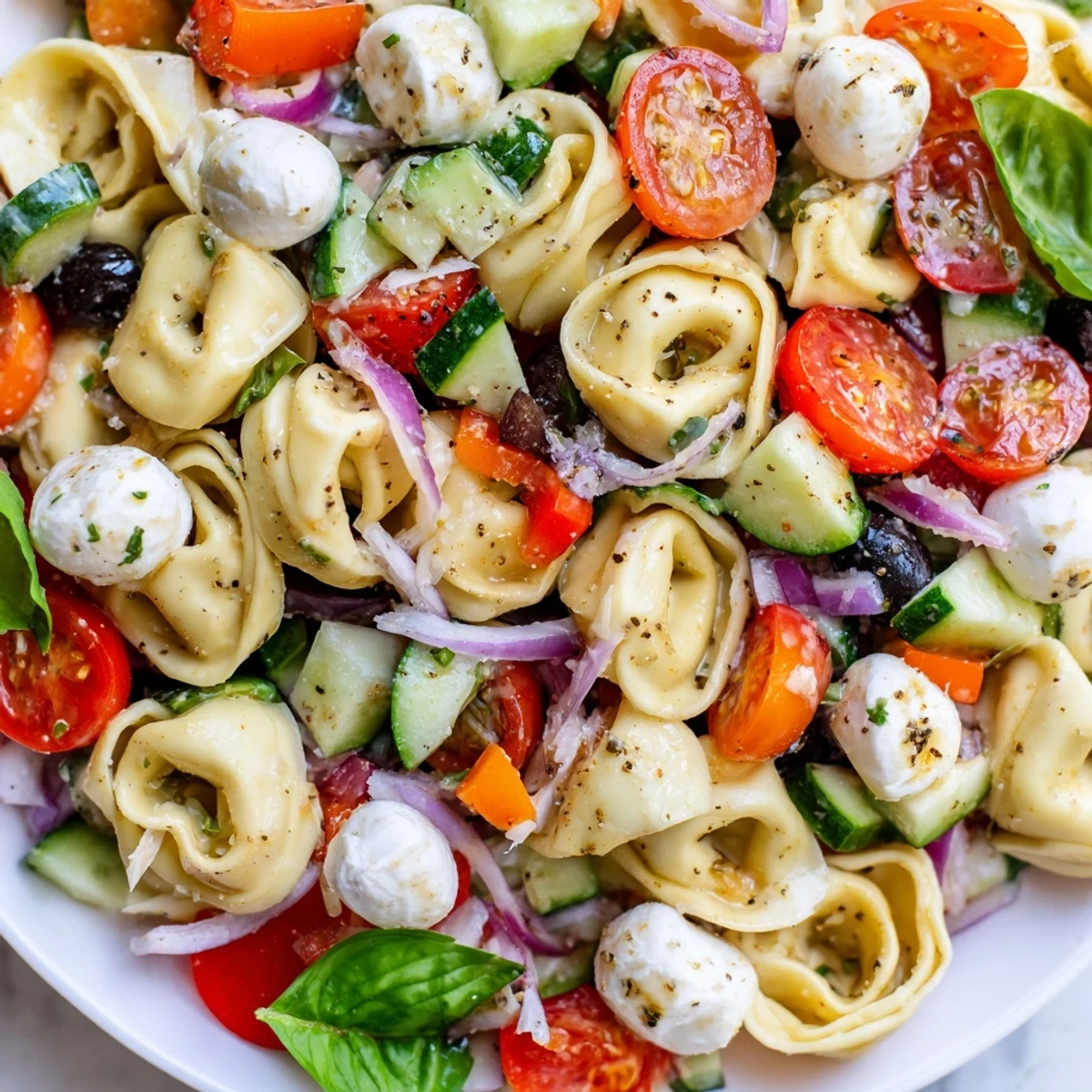 Colorful tortellini salad with crisp vegetables and tangy Italian dressing in a serving bowl