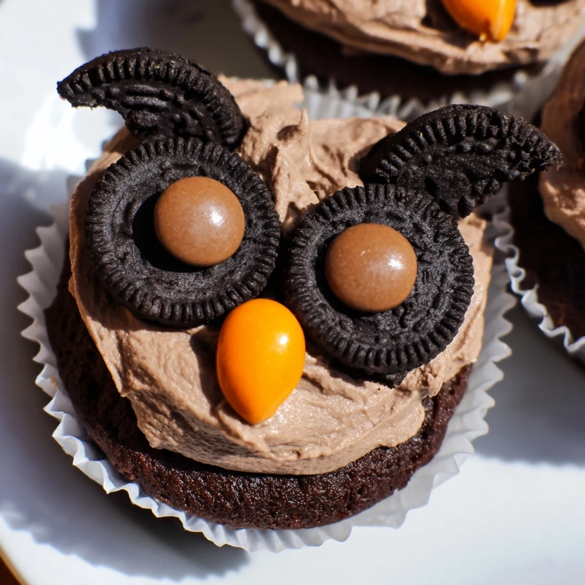 Whimsical Oreo Owl Cupcakes decorated with rich frosting and golden candy beaks ready to serve