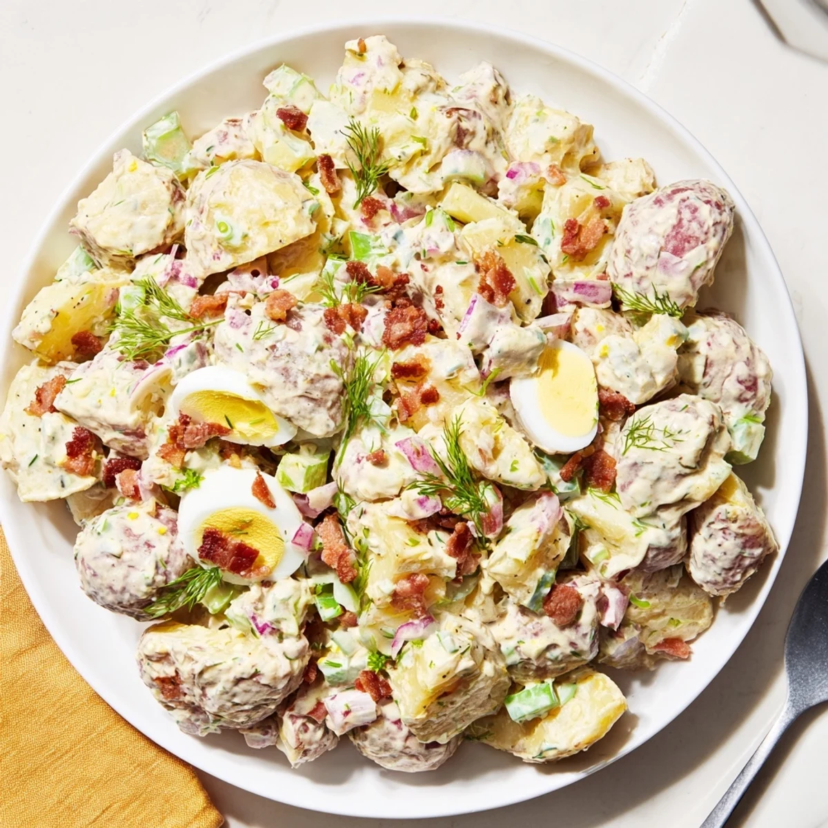 Creamy Steakhouse Potato Salad with crispy bacon, tangy pickles, served with steak