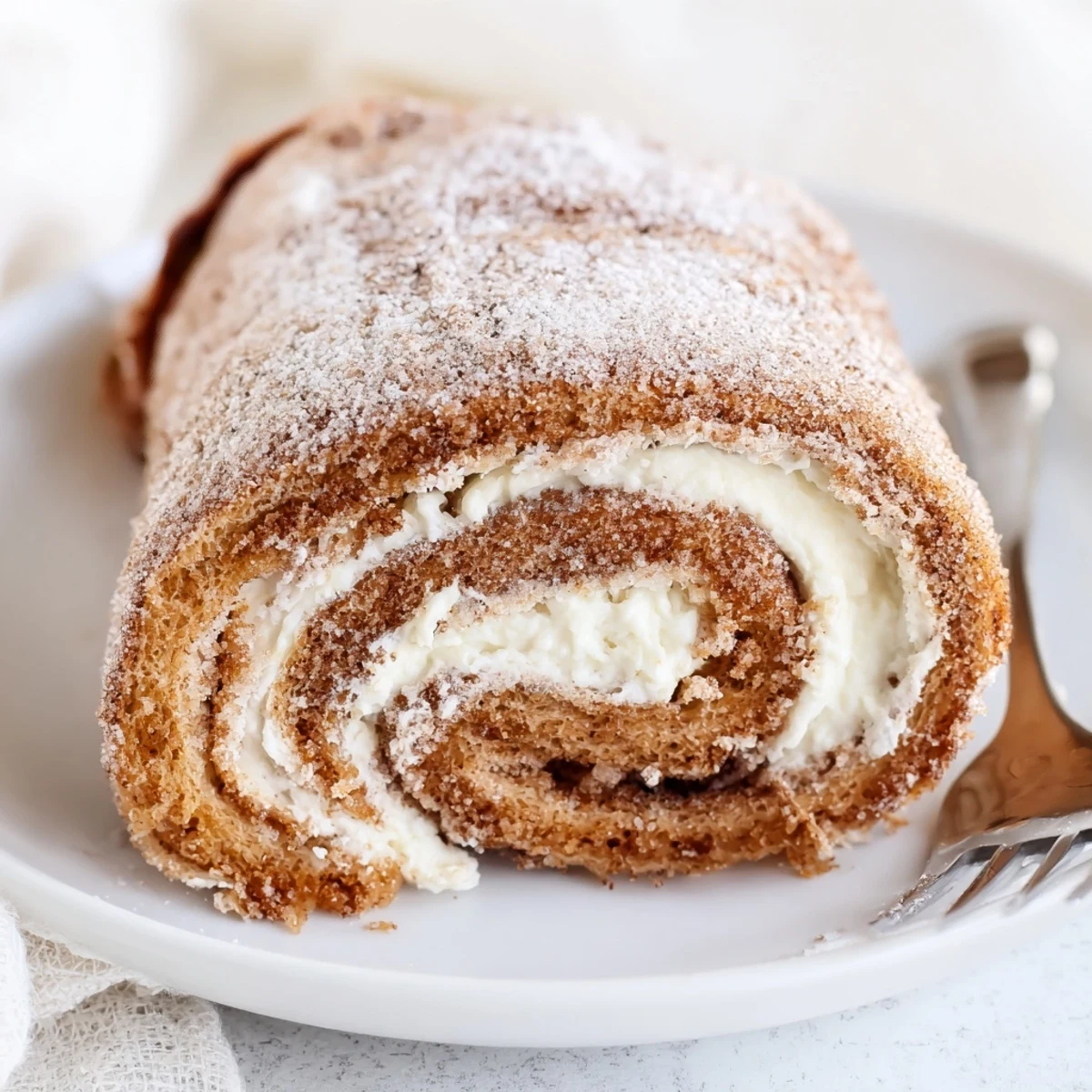 Pan seared Cinnamon Roll French Toast Roll Ups with buttery skillet edges, handheld