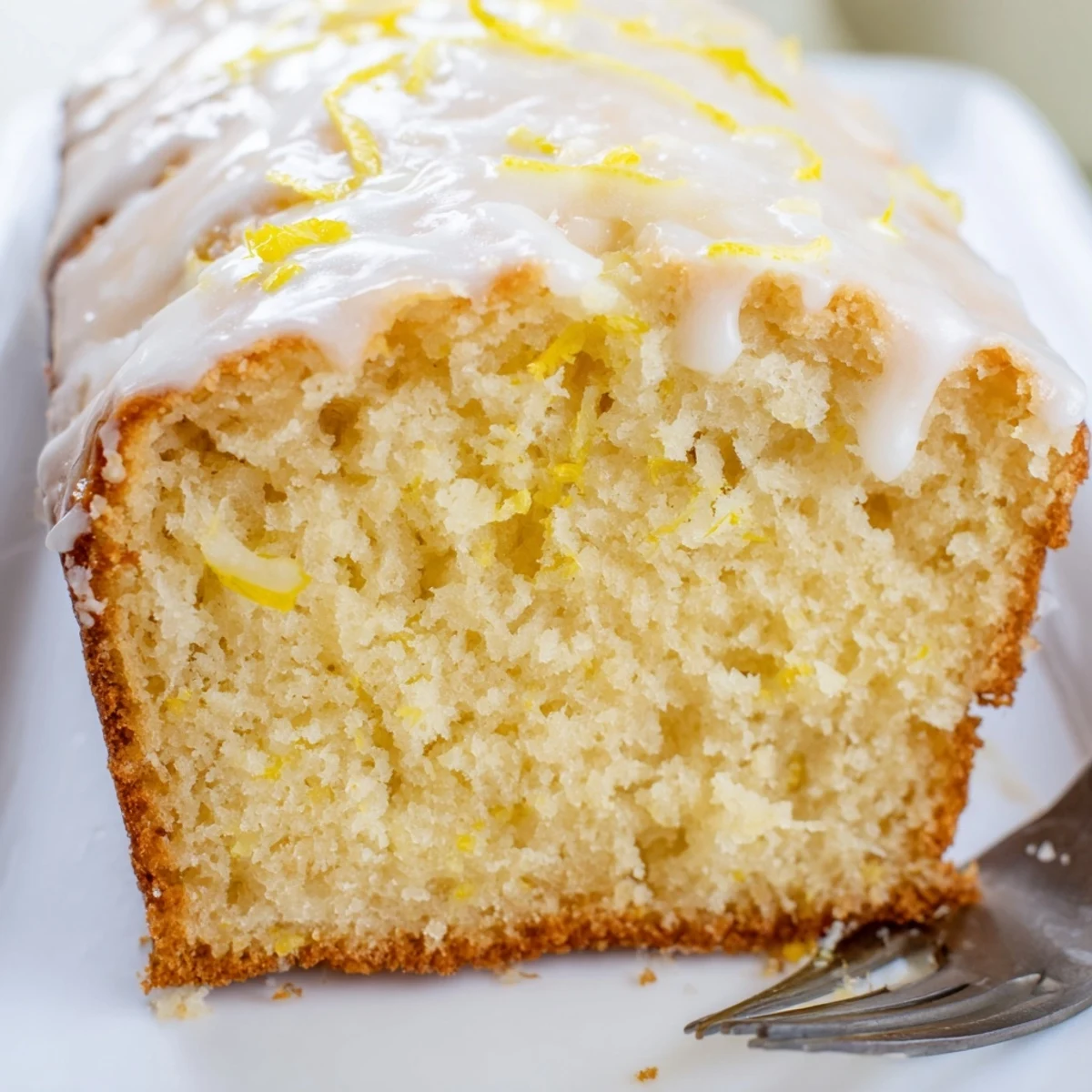 Moist lemon loaf cake sliced to reveal tender crumb with powdered sugar topping
