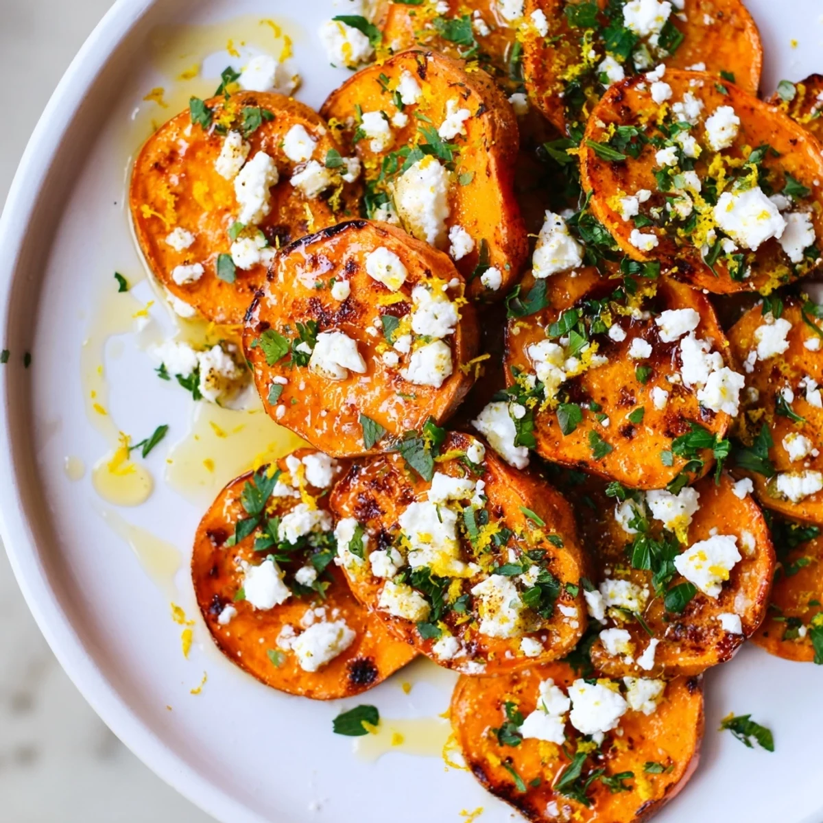 Golden roasted sweet potato rounds topped with crumbled feta cheese and honey drizzle