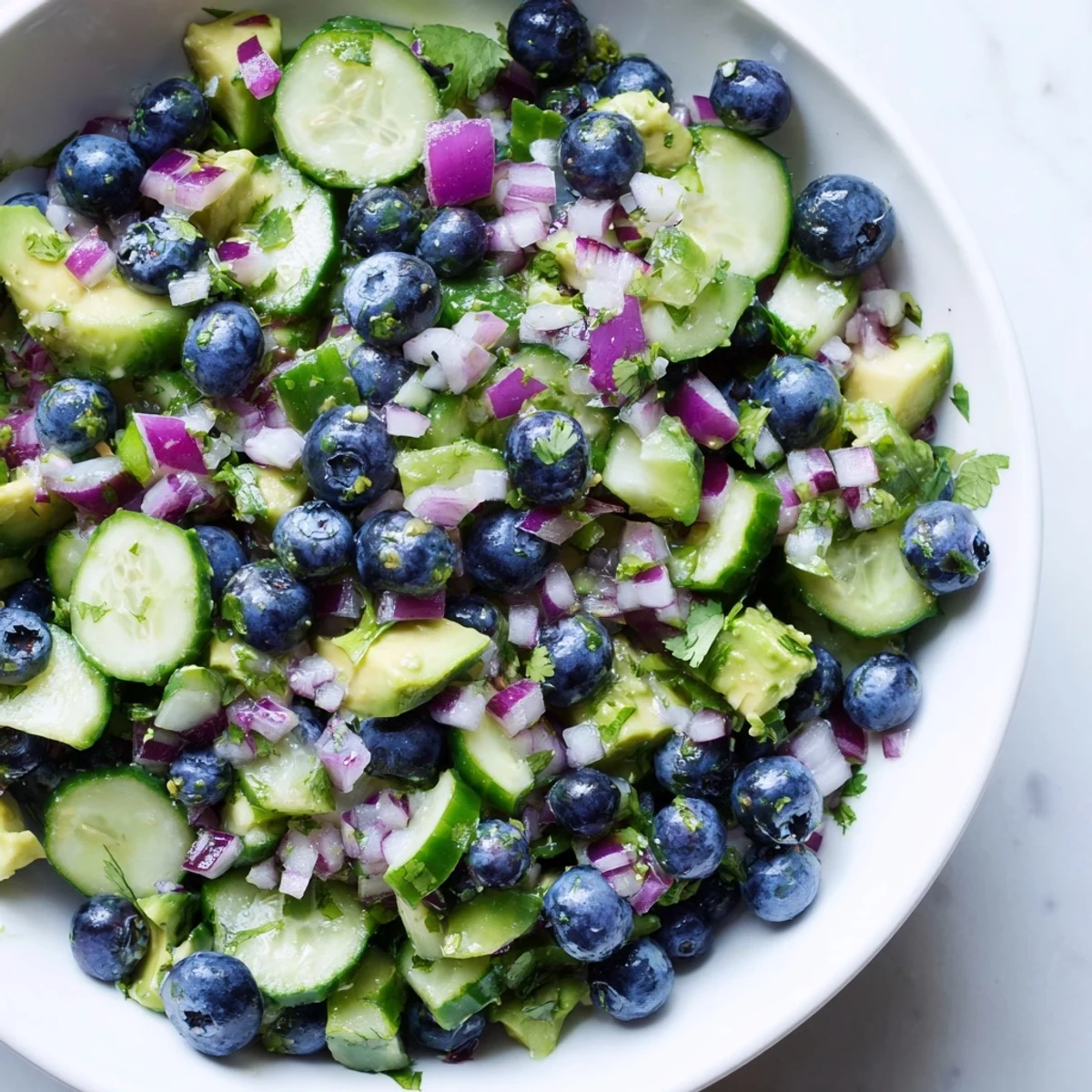 Blueberry cucumber salsa served with tortilla chips on a rustic wooden cutting board