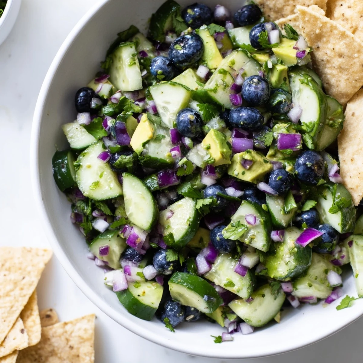 Close-up of fresh blueberry cucumber salsa topped with lime juice and jalapeño