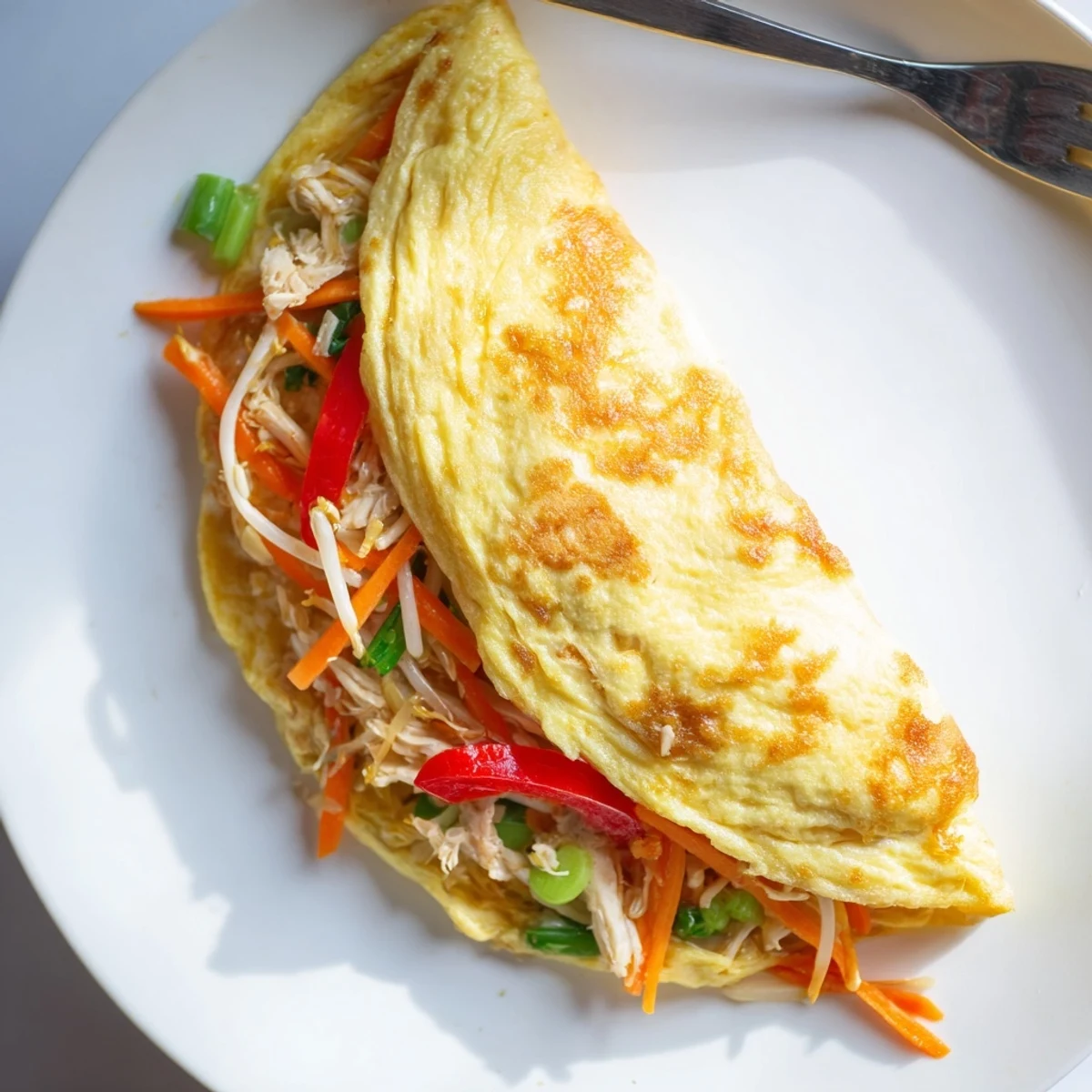Fluffy Chinese omelette with colorful bell peppers and bean sprouts on a plate