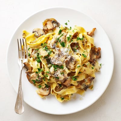 Savory truffle mushroom pasta served with fresh parsley and Parmesan cheese.