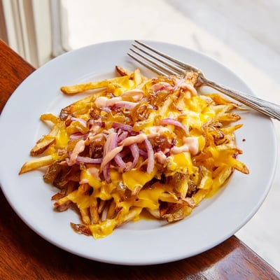 Animal Style fries drizzled with tangy sauce melty cheese and savory golden onions